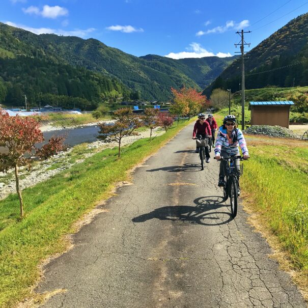 Australian tourists cycling along the river in Japan