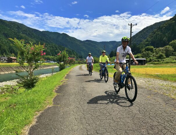 川沿いでサイクリングを楽しむ日本人観光客