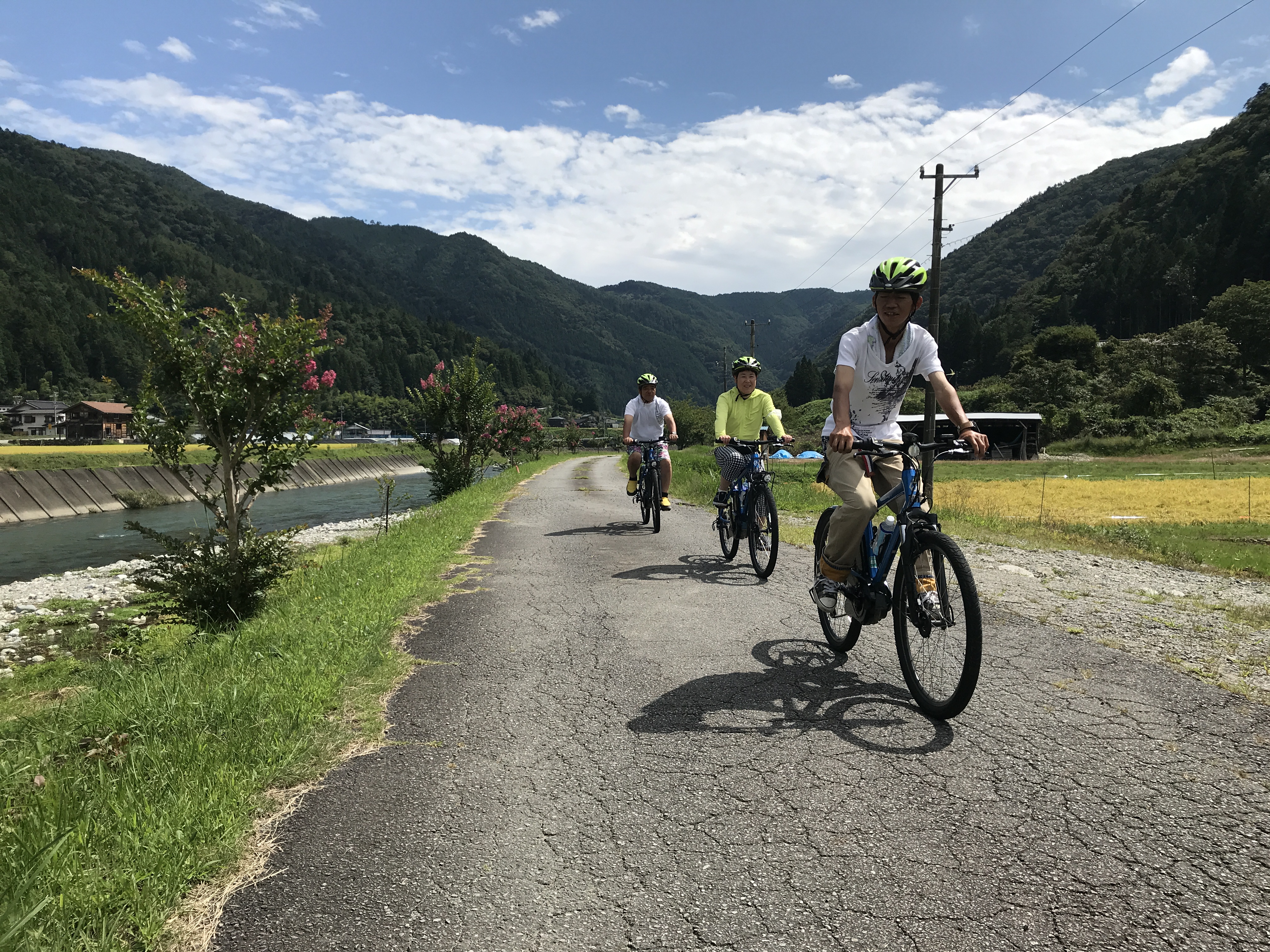 馬瀬川沿いを電動自転車で走る日本人観光客
