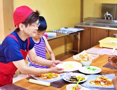 子供とピザづくり体験を教えるお母さん