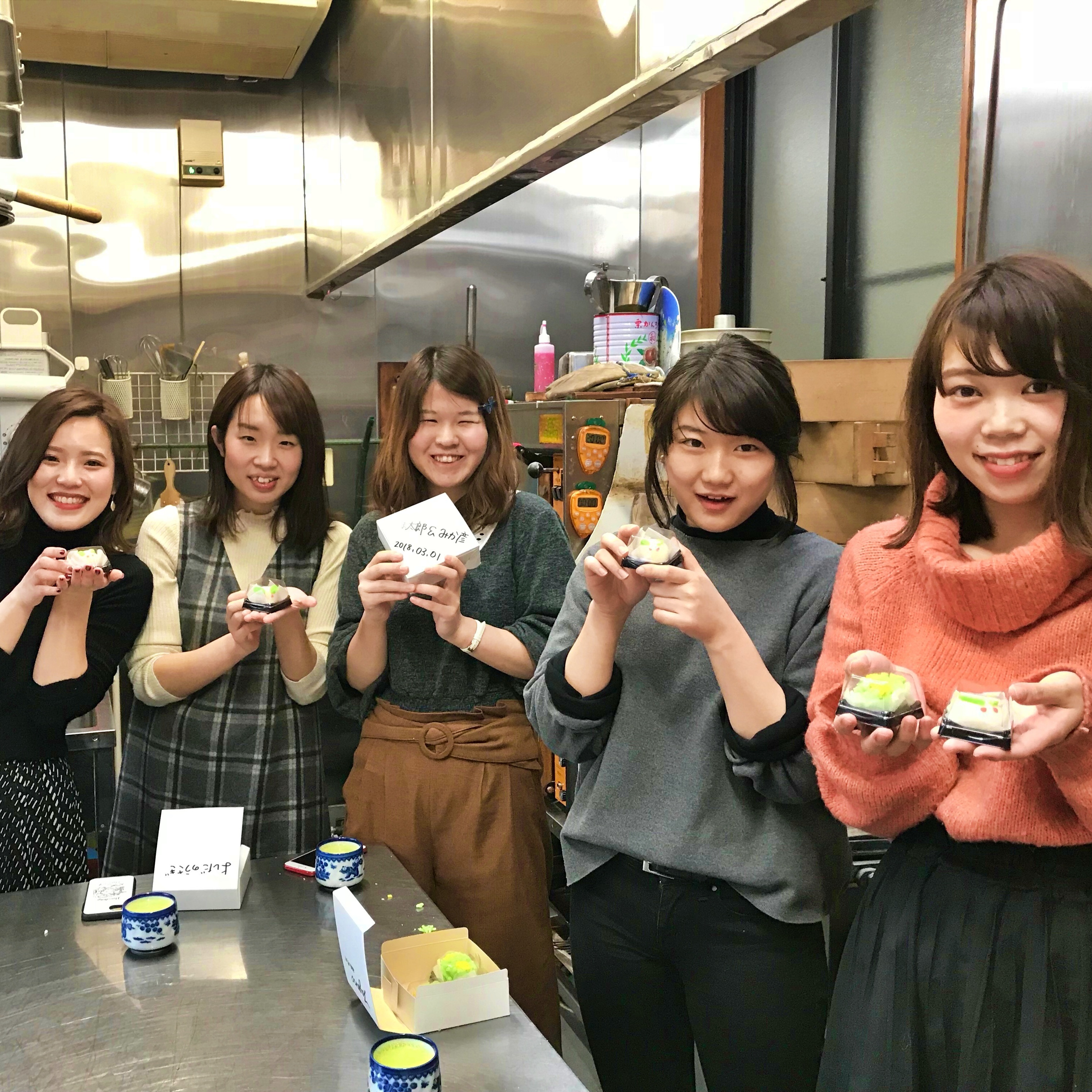 和菓子を手に笑顔の女子旅グループ