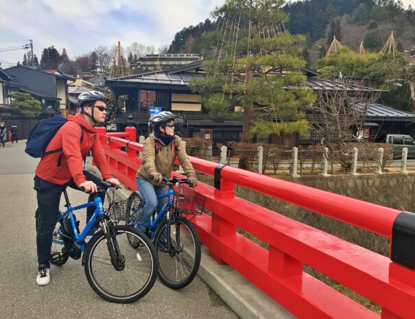 A couple enjoying bike ride at the bridge in Takayama