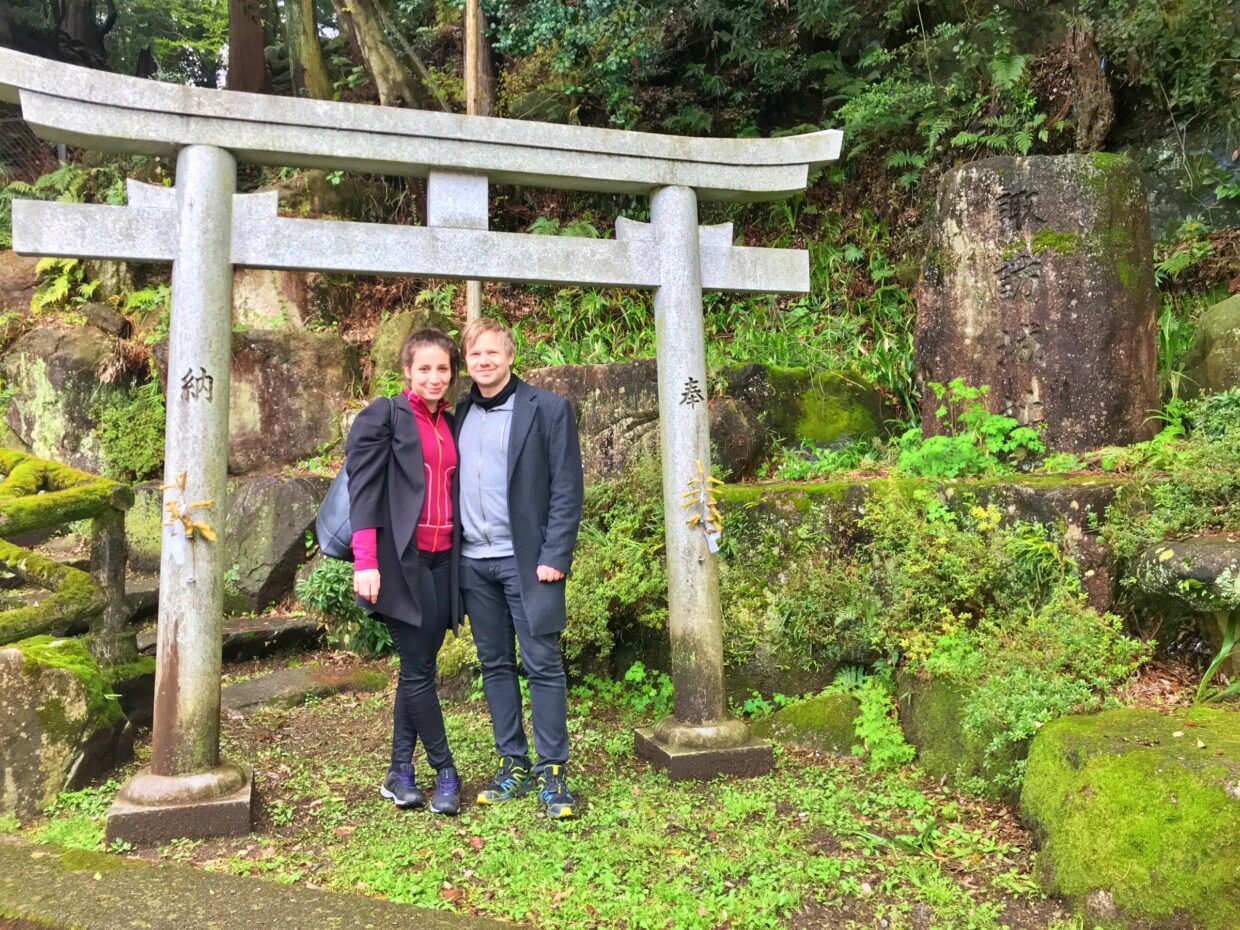 Foreign travelers in front of Shinto shrine gate