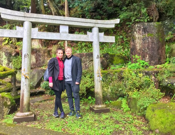 Foreign travelers in front of Shinto shrine gate